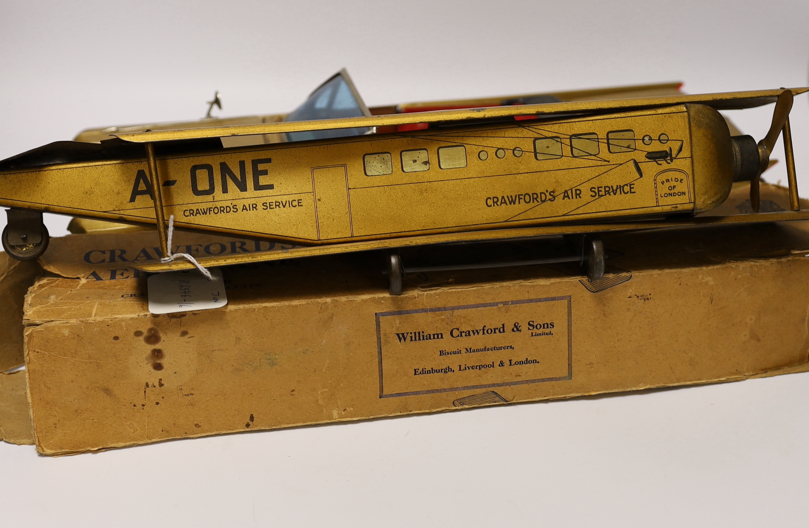 Four tinplate toys; a Frog Interceptor Fighter, a Bandai battery powered Cadillac Convertible (4025), a Crawford’s Biscuits Aeroplane and a clockwork Tri-ang Minic London Transport Double deck bus